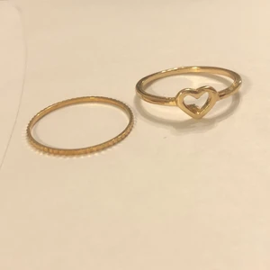 Ringar - Två stycken oanvända ringar. Hjärtat har en liten ”defekt” som va där från början, se bild. Hjärtringen är 17mm och den andra cirka 18mm i diameter. Båda för 15kr pga hjärtats defekt, frakt på 13kr betalas av köparen💗