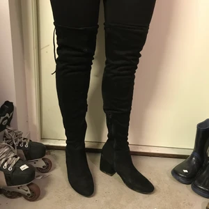 Höga stövlar  - Mocka liknande svarta högstövlar med medelhög klack. Mjukt skaft. Bekväma. Mycket litet hål på höger knä som nästan inte syns. Storlek 40. Frakt tillkommer. All