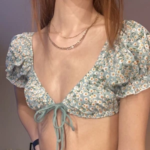 Blommig sommartopp - Gullig topp med knytning i fram! Tyvärr finns det ingen lapp i, men skulle säga att den är XS-S och A-B i kupa. kom med egna prisförslag, säljer ut mycket ur min garderob så vid snabb affär jag kan tänka mig en smärre kostnad.🥰