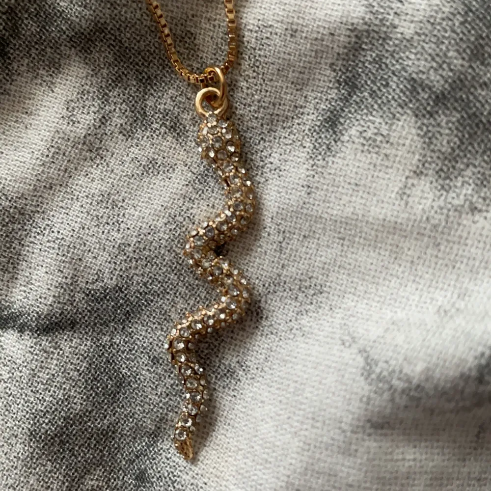 Ett gulligt halsband med en orm på, ormen har små diamanter på. Aldrig använd. Accessoarer.