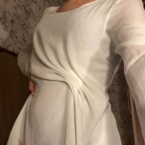 Vit blus med detalj  - Köpt från bubbelroom för länge sen men inte kommit till någon användning, den går över rumpan och har en detalj på sidan som gör att tröjan ger en timglas figur 