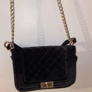 En svart basic handväska från Ur & Penn med silverdetaljer 