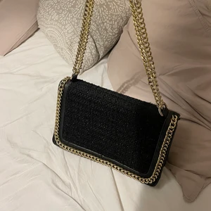 Väska svart/guld/glitter - Jätte snygg väska i svart med glitter och guld detaljer. Köpt för cirka 600 kr i en butik i köpenhamn. Mitt pris är 300 kr. Säljer för att den inte kommer till användning🖤