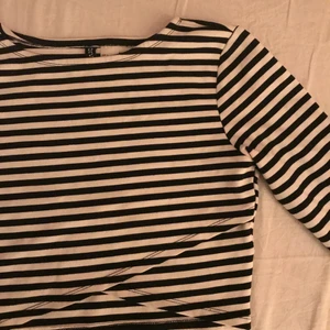 Svart-vit randig topp från H&M - Väldigt fin svart-vit randig omlott långärmad croppad topp strl S ifrån H&M med fin detalj och i väldigt bra kvalite och skick som fungerar perfekt till både vardag som fest💕