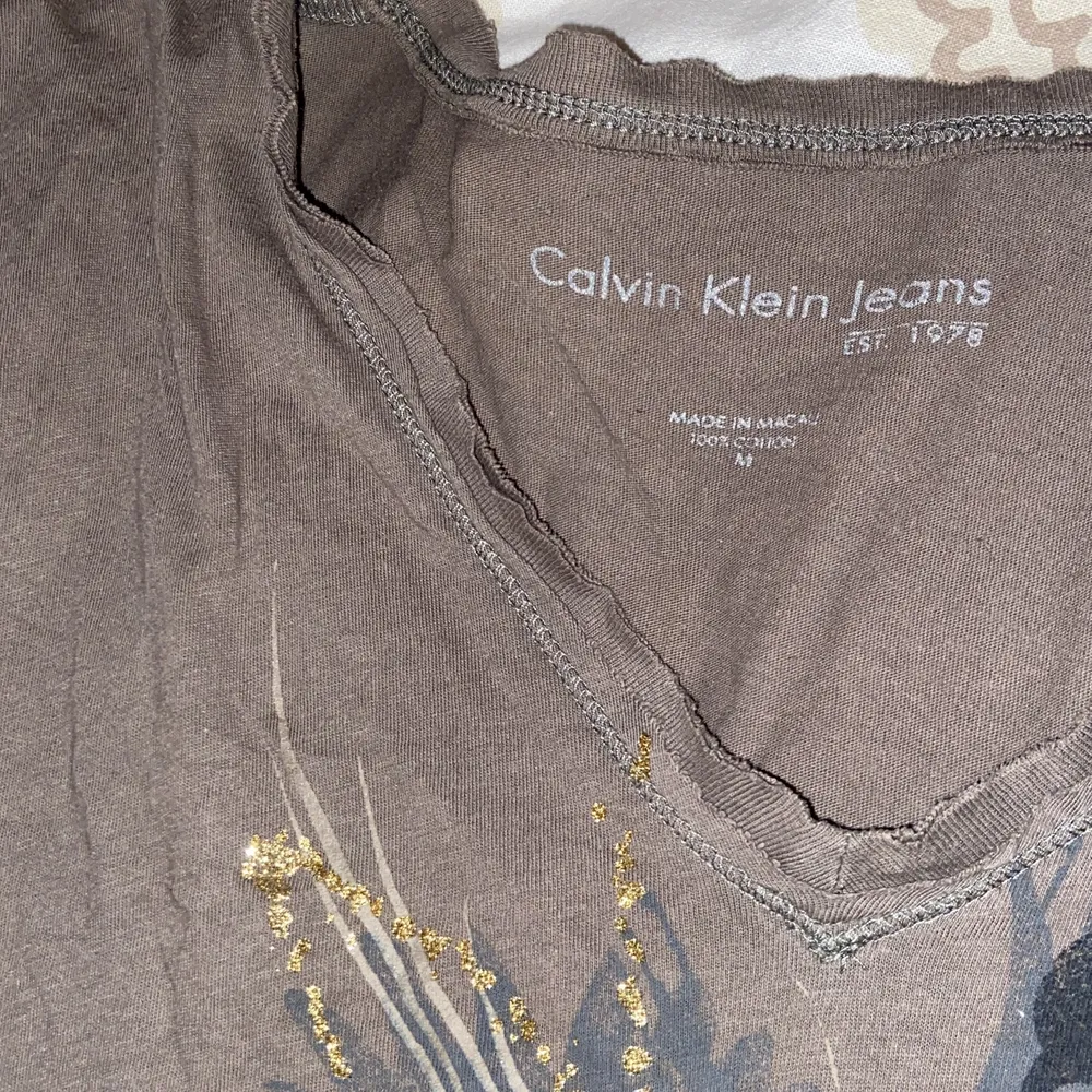 Från Calvin Klein men ganska dåligt skick! Köpte second hand och tror nån har klippt i den där uppe, se bild 3. T-shirts.