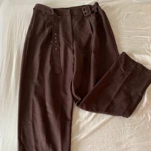 Bruna/lila byxor - Helt oanvända byxor med dad-fit och bälte i storlek 46! 🌸 De är mer åt det mörklila/plommonlila hållet i verkligheten ✨ Köparen står för frakt 😊