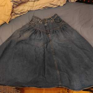 En lång kjol i jeans tyg. Midjan är 31-32 cm och kjolens längd är 80 cm