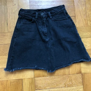 Monki kjol strl 34 - Svart jeanskjol från Monki i strl 34. Kort högmidjad jeanskjol med fickor både bak och fram och lite fransar vid slutet! 