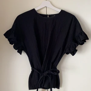 Topp med volangärm  - Superfin topp köpt från ginatricot med volangärm och knyt i midjan (domhär att ta loss). I storlek 34 men passar även 36. Frakt tillkommer 45/66kr beroende på spårbar eller ej💜