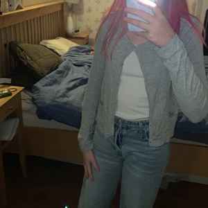 Tunn grå kofta - Vissa av knapphålen är lite slitna men det är inget som ska märkas. Tröjan har två små fickor. Koftan är stor för sin storlek och skulle säker funka för någon med storlek 170