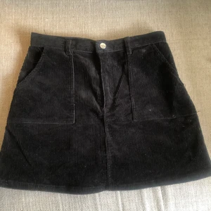 Manchester kjol - Svart Manchester-kjol från monki i storlek 40. Passar mer en storlek 38. Bredd i midjan 36 cm och längd 40 cm.