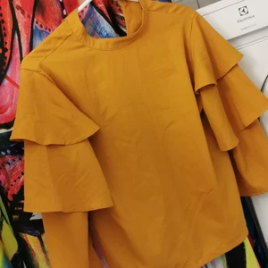 Brandgul blus - Brandgul blus. Från Boohoo, trekvarts volang ärm. 