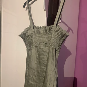 Grönt silkes linne - Super gulligt militär ish grönt linne i silke, sitter super fint med gummiband runt bröst delen, skriv för fler bilder❤️ har en liten lagning på ena siden men syns knappt när man har på sig den