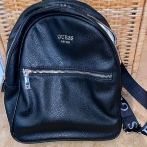 Guess - Snygg ryggsäck svart skinn från märket Guess. Snygga remmar bra innerfack får plats med en 11 tums dator se bild. Använt knappt, behöver rensa pga flytt. 