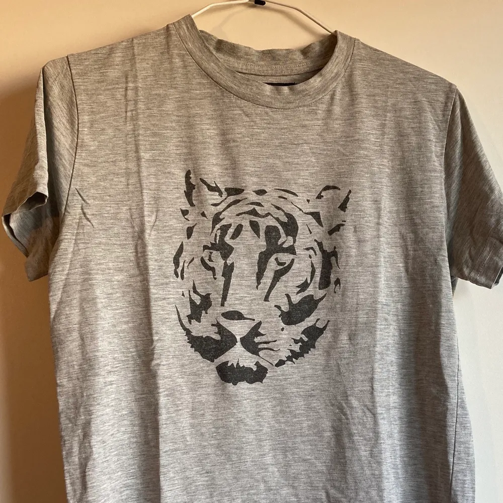 Grå t-shirt med tigermotiv från Tiger of Sweden. Använd. Fått av ett ex. Hela tiden funnits ett litet hål i ena hörnet där etiketten sitter (se sista bilden) som inte blivit större trots flitigt använd. Skön! Flyttrensning! Samfraktar såklart vid köp av flera plagg. Som med allt jag säljer går hälften av pengarna till läkare utan gränser. . T-shirts.