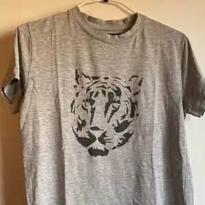 Grå t-shirt med tigermotiv från Tiger of Sweden. Använd. Fått av ett ex. Hela tiden funnits ett litet hål i ena hörnet där etiketten sitter (se sista bilden) som inte blivit större trots flitigt använd. Skön! Flyttrensning! Samfraktar såklart vid köp av flera plagg. Som med allt jag säljer går hälften av pengarna till läkare utan gränser. 