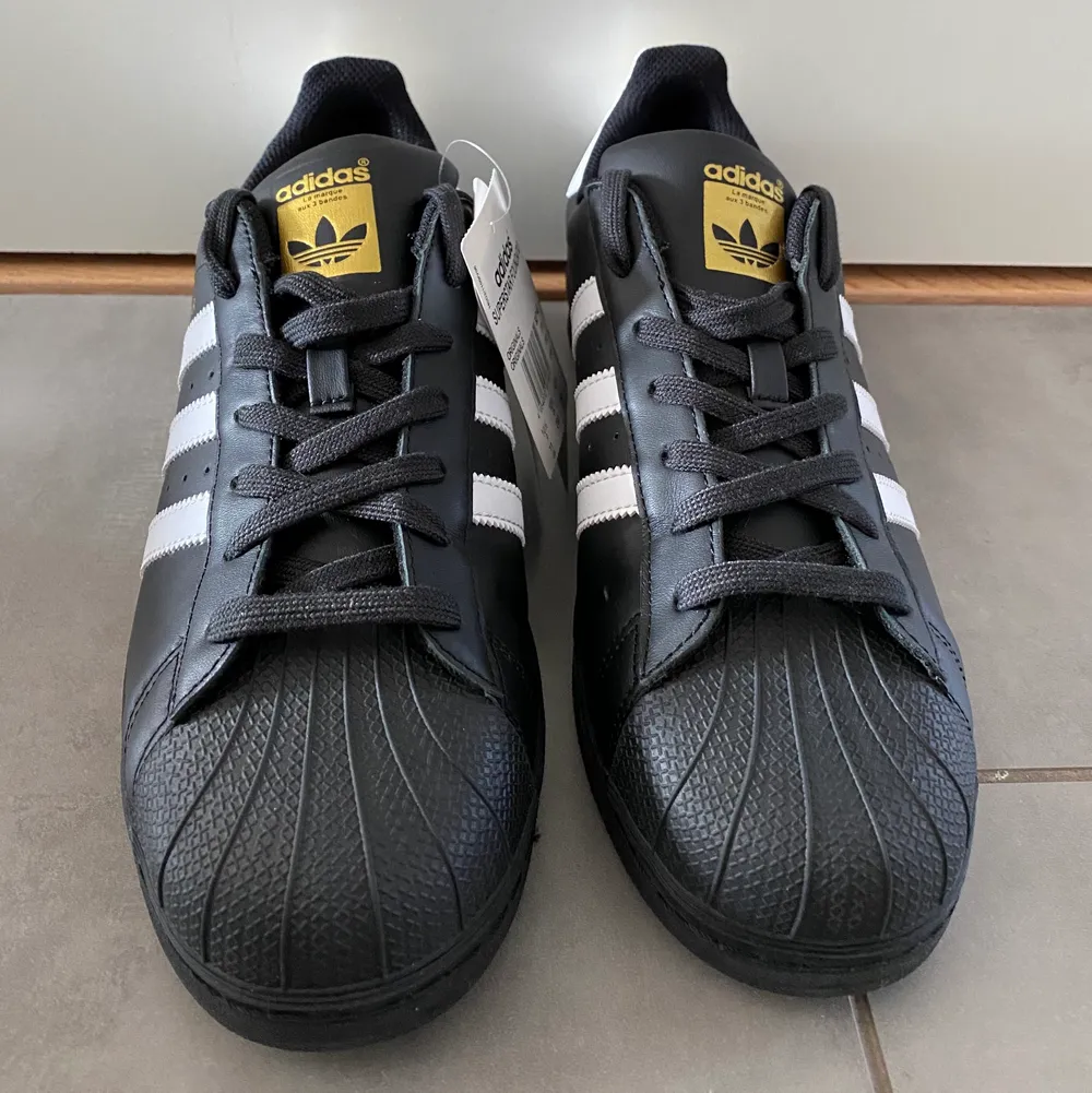Adidas Superstar Foundation Skor. Svarta med vita träck och guldiga detaljer. Helt nya och obrukade. Klassiska adidas skor, jättesnygga! Kartong medföljer vid intresse.. Skor.