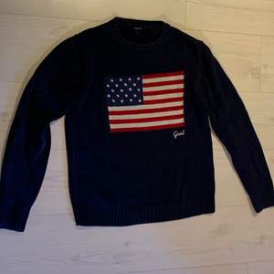 En mörkblå ”stickad” gant tröja med flagg tryck i storlek S