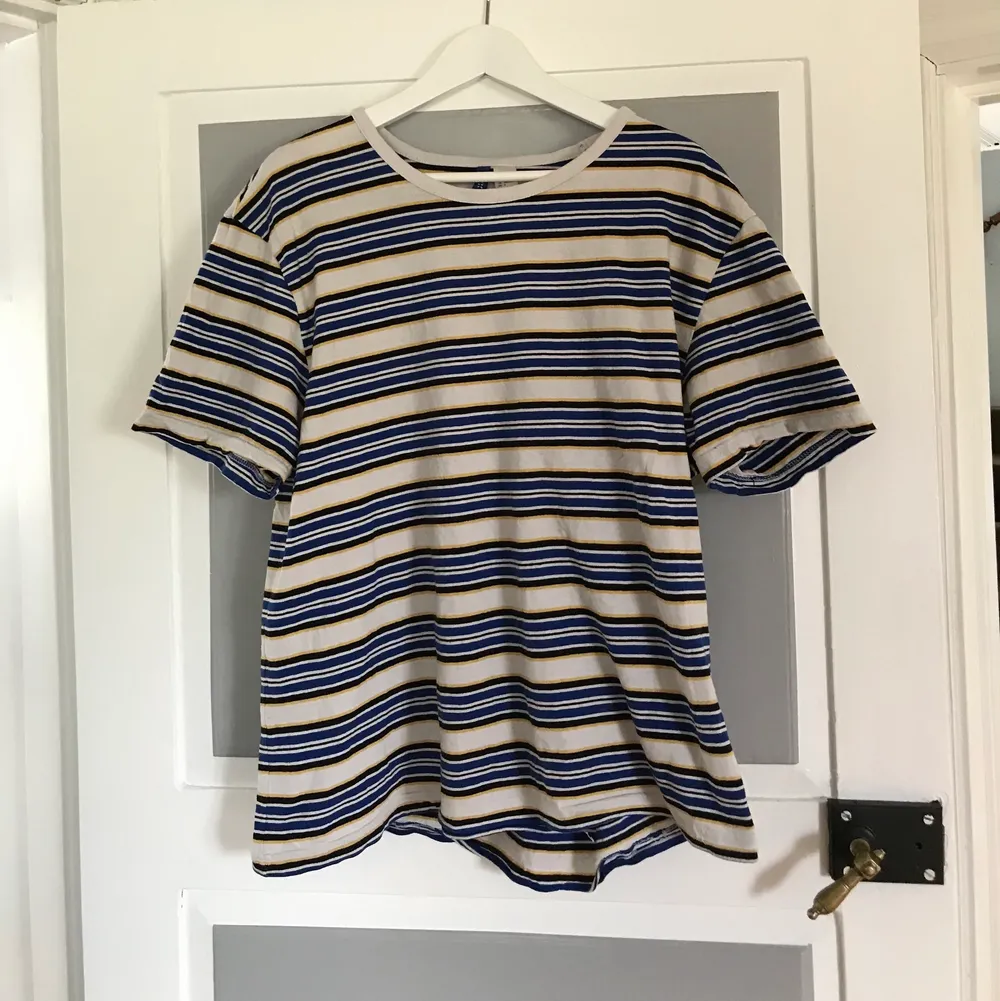 En jättesnygg vit t-shirt med ränder i gul, blå och svart. Använd en del och är i lite krassligt skick då sömmar har börjat gå upp:( Köpt på H&M i storlek L. säljer pga den inte används. 30kr + frakt.. T-shirts.