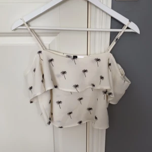 En vit topp - En vit kort topp i storlek 32. Är andvänd ca 2 gånger.