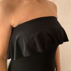 Axelbandslös klänning Gina Tricot - Använd 1 gång. Axelbandslös, lite kortare nertill där fram. Köparen står för eventuell frakt.