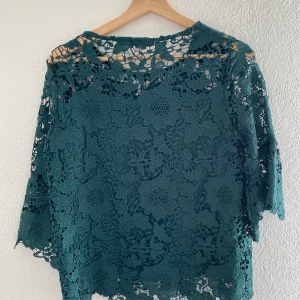 Blus  - En jättefin blus med spets. Blus armarna är 3/4, blusen är fodrade från bröstet. 