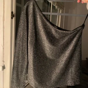 Glittrig Oneshoulder - Säljer denna glittriga oneshoulder topp från Nakd i storlek S, jättefin å passar jättebra till utgång eller liknande. Endast använd en gång och är i bra skick, bara att skriva om ni är intresserade av fler bilder💕pris kan diskuteras 