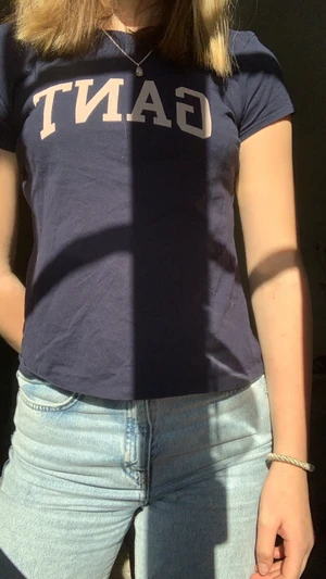 GANT, 146/152 - Jag säljer min marinblåa gant t-shirt med ljus rosa text. Nästan nyskick, pris kan diskuteras. Skriv privat för fler bilder!☺️