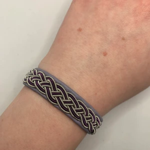 Tenntrådsarmband  - Handgjort Tenntrådsarmband, lila. Materialet armbandet är gjort i är lammskinn, och flätan är gjort i tenntråd. Armbandet kan hålla i flera år. Om du har någon fråga kan du gärna skriva en kommentar eller meddela mig.