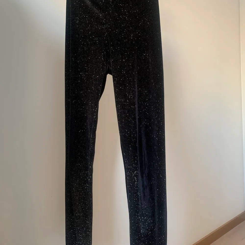 Shiny leggings with golden glitter. They are warm, comfortable and stretchy, and work great as a statement going out piece, or under dresses. The fit is slim and they are highwaisted. I have owned these for a few years and the glitter has stayed on quite well. They are in good shape. Size is S (36), but they are stretchy. . Övrigt.