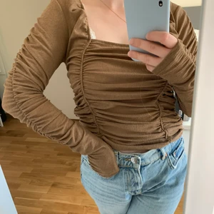 Brun topp från Gina Tricot - En superfin brun topp från Gina Tricot. Köpte den här på Plick men satt lite lösare än jag tänkte mig så därför säljer jag vidare! Storlek M och lappen sitter kvar! Köparen står för frakt 🥰