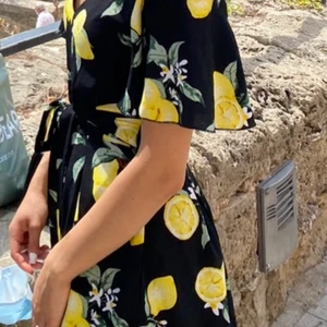 Somrig playsuit i svart med ett citron print, använd endast 1 gång!  - En playsuit som är som ny, använd endast en gång i storlek S. Den har lösa ben och ser nästan ut som en klänning. I ett väldigt skönt tyg och så gott som ny.