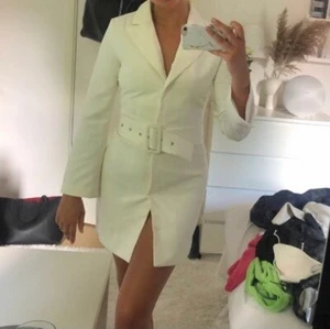 Kavajklänning  - Vit kavajklänning från nelly i storlek 36, med en fin slits detalj på armen