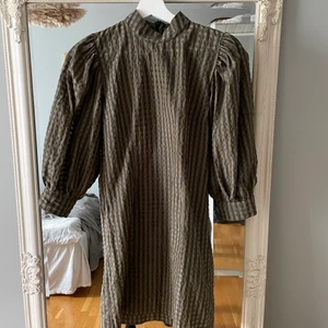 Ganni klänning - Säljer min jättefina klänning från Ganni. Storlek 36 men passar även en 34a. Två hål i ärmen som är lagade, dessa syns verkligen inte i och med att ärmarna är puffiga. 