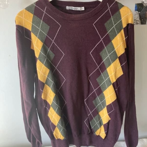 Stickad tröja med argyle mönster - Småstickad vinröd tröja med gult och grått mönster! Från dressman men köpt secondhand. I bra skick utan skador. :)