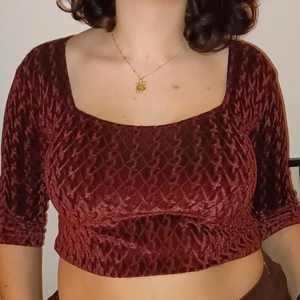 Beyond Retros Vinröda croptop - En vinröd croptop med squared neckline från Beyond Retro i storlek M. Små flätliknande mönster och lite kortare ärmar. Super gullig till våren, sommaren och hösten! 