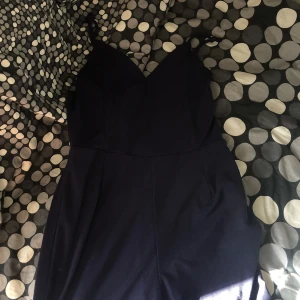 Mörkblå jumpsuit - Jätte söt jumpsuit som använts 1 gång. Går att justera längden på snörena genom att göra knut på de, som jag gjort. Då passar den perfekt för mig som är 163 cm, annars funkar den bra för alla över 167 cm + med. Jätte fina detaljer på ryggen!