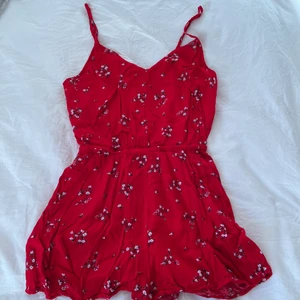Röd playsuit med små blommor strl S - Röd playsuit med små blommor i storlek S/36 från hm. Med fickor och resårband i midjan. Justerbara band 🥰 frakt 52kr☺️