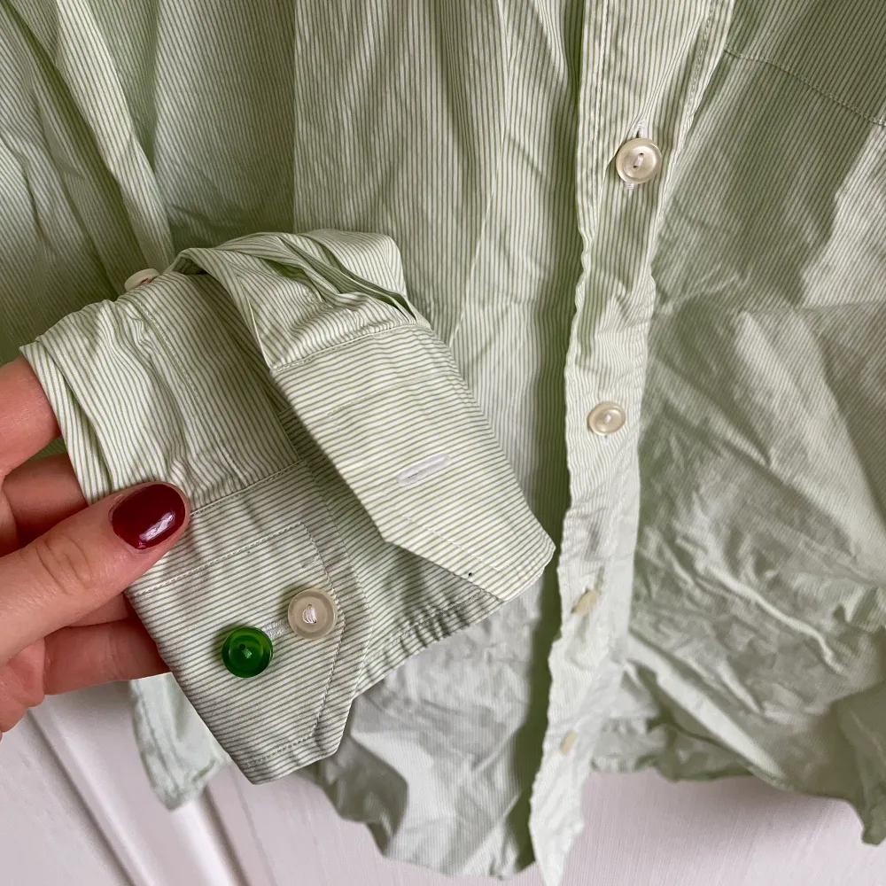 En pastellgrön och vit randig skjorta. Slimfit, väldigt fin. Ber om ursäkt då jag inte strukit den, men om ni hör av er gör jag gärna det. Den är retro och köpt på loppis. . Skjortor.