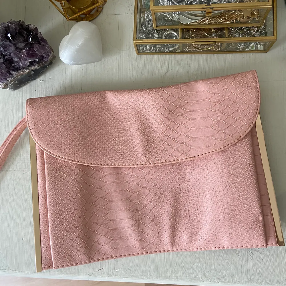 Baby rosa clutch väska från Primark, med ormmönster & guld detaljer. Handledsrem men ingen kedja medföljer. ALDRIG använd så i utmärkt skick! . Väskor.