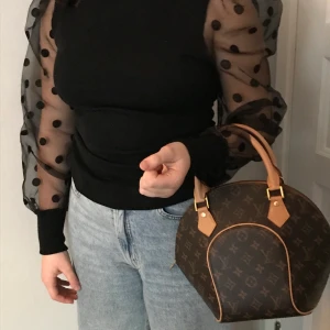 Blus/tröja - Aldrig använd och i bra skick! Svarta prickar på ärmarna och ribbat matrial vid resten av plagget. Kommer inte till andvändning för att den är för liten och inte min stil. 