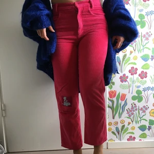 Rosa byxor - Manchesterbyxor med lapp som föresteller dalmatiner på ena benet. Byxorna står i barnstorlek men skulle säga de är xs