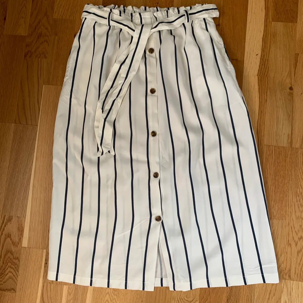 Jättefin blå och vitrandig kjol med knappar på framsidan och knyte i midjan, från h&m. Aldrig använd och storlek M, frakt tillkommer (men varierar beroende på hur mycket paketet väger) men kan mötas upp i Göteborg💕💕. Kjolar.