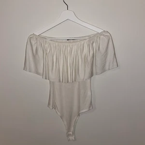 Body - En vit off shoulder body med volang. Aldrig använd. frakt ingår i priset