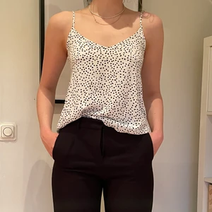 Prickig topp strl 34 - Prickigt linne i vitt och svart i strl 34 från h&m, bra skick.✨GRATIS FRAKT✨