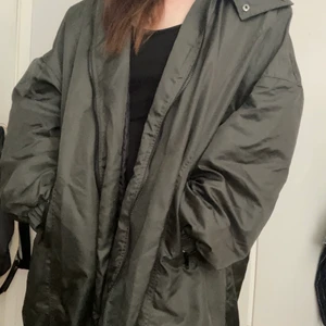 Longline bomberjacka Collusion - En lång bomberjacka i oversize från Collusion. Stor i storleken och passar säkert upp till XXL. Militärgrön. Blir nog för lång om du är kortare än 165.