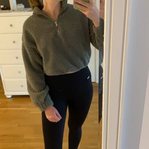 Mörkgrön tröja  - Mörkgrön croppad tröja i mysigt material. Storlek XS från Gina Tricot. Dragkedja upptill.