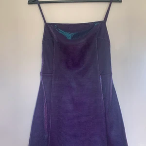 Kort klänning Urban Outfitters - Kort klänning som skiftar väldigt fint i lila och grönt, den har större ”effekt” än vad bilderna visar. Kommer aldrig till användning, endast använd 2 gånger. 