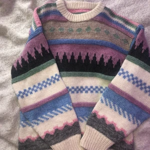 Mönstrad stickad tröja - Stickad tröja i ul med unikt mönster!!💓 köpt secondhand i USA. Jag har bara använt den enstaka gånger,är i bra skick. Funkar bäst om man har något under då den är i ul, lägg endast seriösa bud‼️👍🏼 passar nog allt från S till L då den e oversized:)