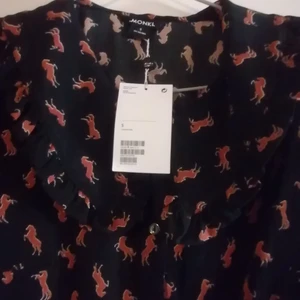 Monki Vivianne dress S CN165/88A - Trendig rolig klänning med volangkrage, resår i midjan och knäppning från halsen och hela vägen ner. Svart med bruna hästar, helt ljuvlig!!! Strl S en passar även M pga resåren. Lapparna sitter kvar. Kommer tyvärr inte till användning men får jag den inte såld nu syr jag om den till en blus. Det är en klänning som förtjänar att ha kul!!!! 😊 🐎